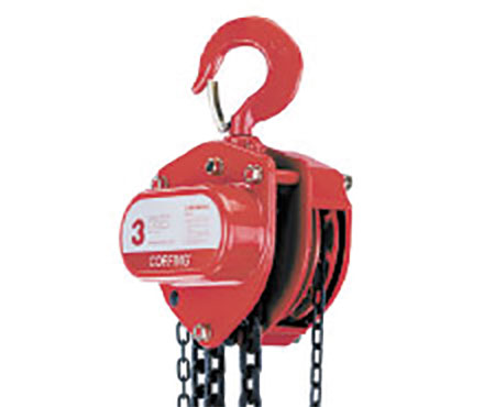A red chain hoist is attached to the side of a building.