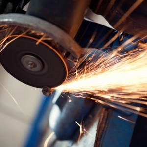 A person is grinding metal with an angle grinder.